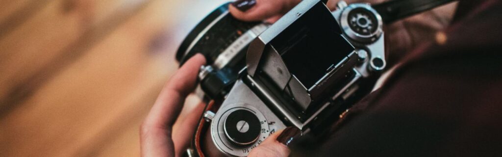 a film photographer holding a vintage camera at a wedding