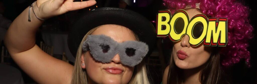 two girls taking an oepn air booth picture