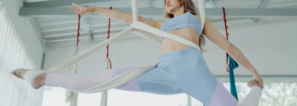 camera facing up to woman doing aerial acrobatics with a wedding at a wedding