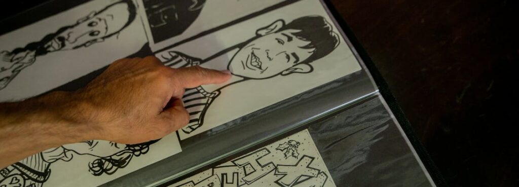 caricature artist at a wedding, zoomed into the page with sketches