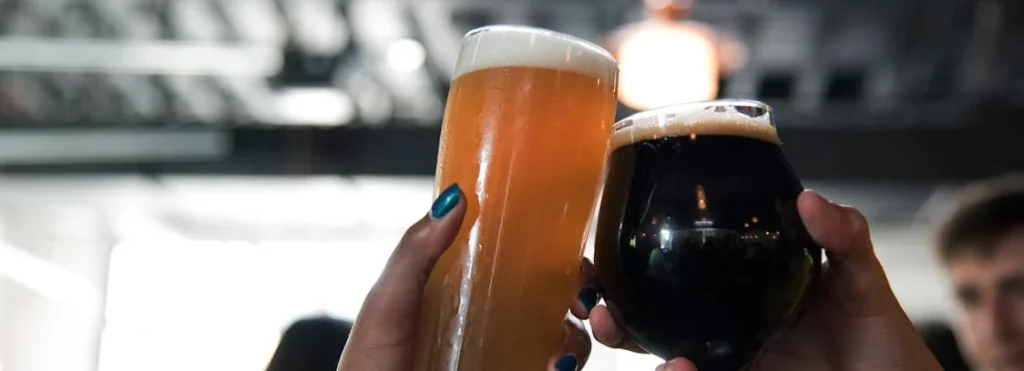 two people toasting a glass of beer and dry stout for craft beer tasting at a wedding