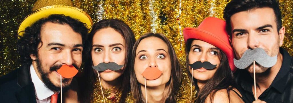 five wedding guests with props taking picutre on roaming photo booth