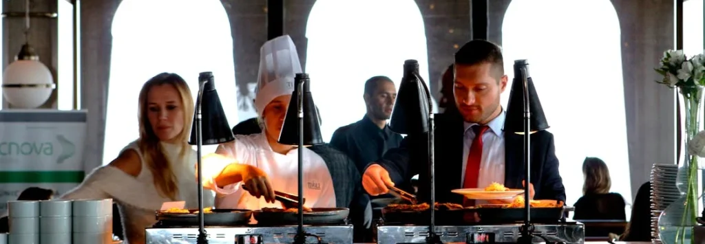 three food station workers at a wedding sharing out food