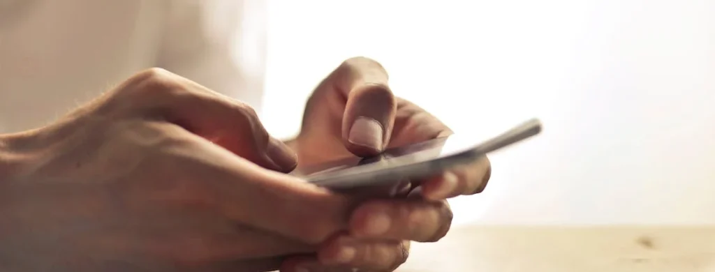 a person's hand holding a phone leaving a message in an interactive wedding digital guest book