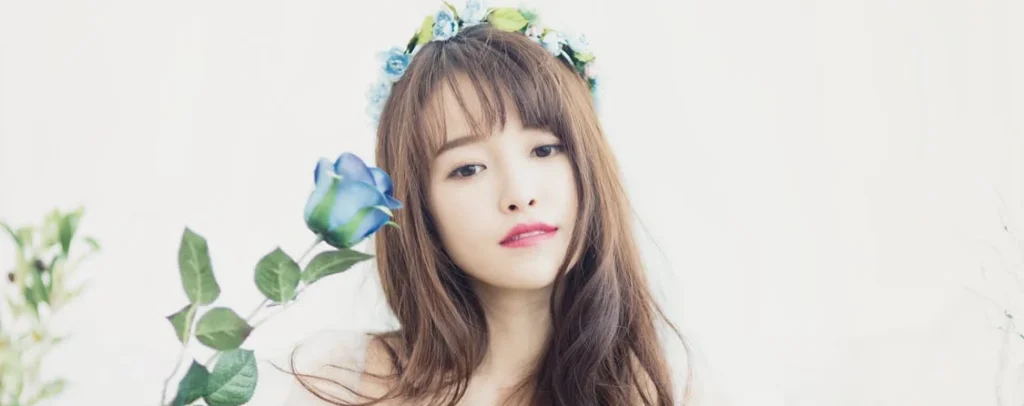 a women wearing a flower crown and holding a blue rose