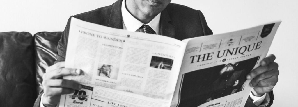 wedding guest reading custom news paper about the bride and groom
