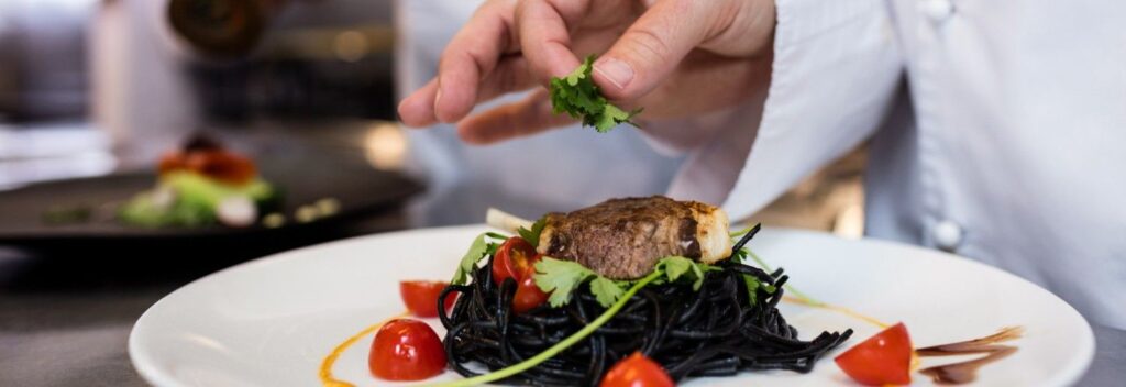 a chef finishing a plat at a fine dining resstaurant in manchester