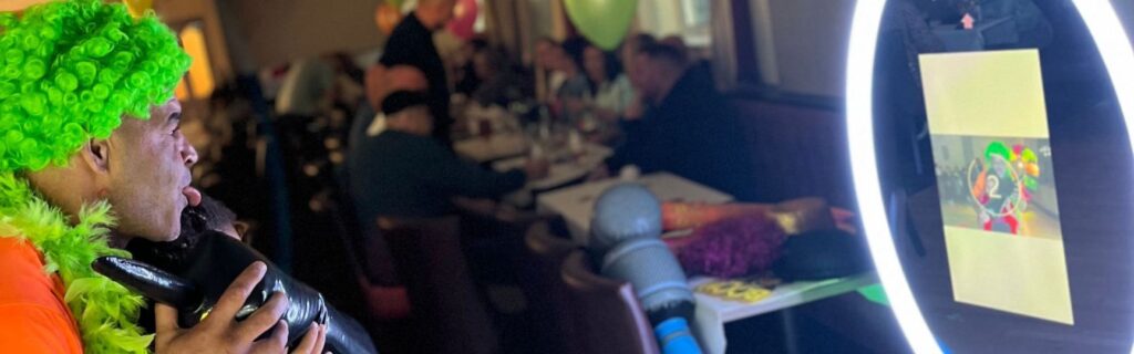 father an daughter using an unmanned photo booth at a party