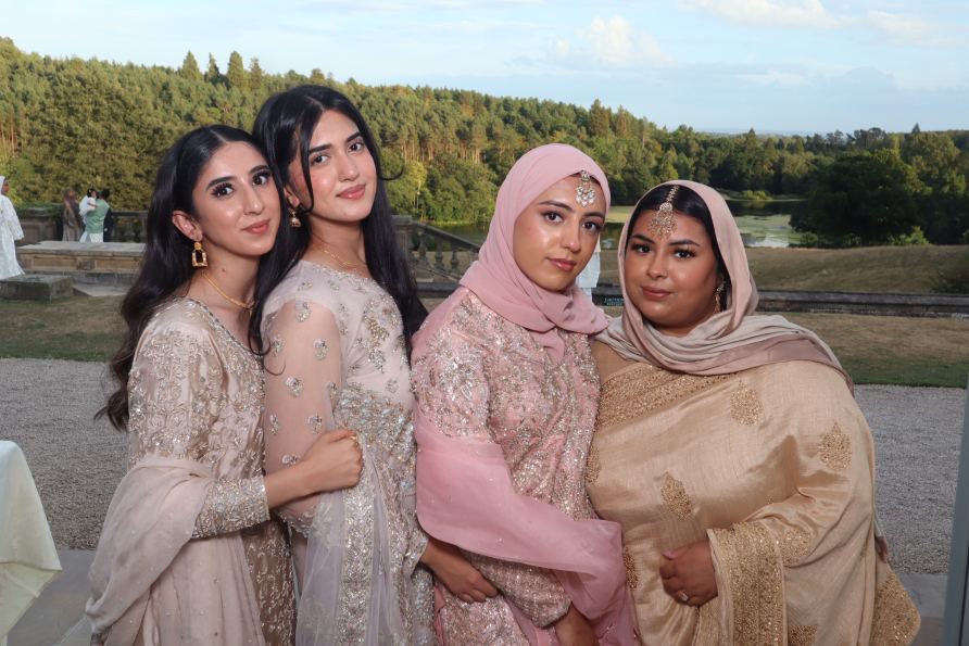 woman at a pakistani wedding taking a picture on a photo booth