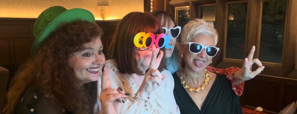 group of women in props taking a photo booth picture