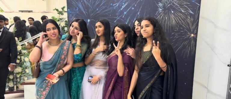 group of girls in saris taking a photo booth picture