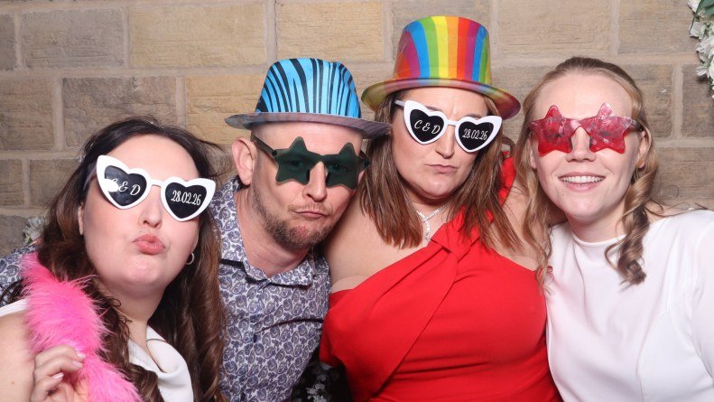 a lesbian couple and their wedding guests at taking a picture at Sitwell arms in Sheffield