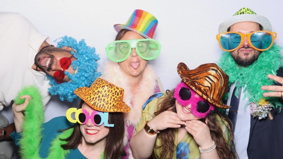 people taking a funny picture on a photo booth at a corporate event